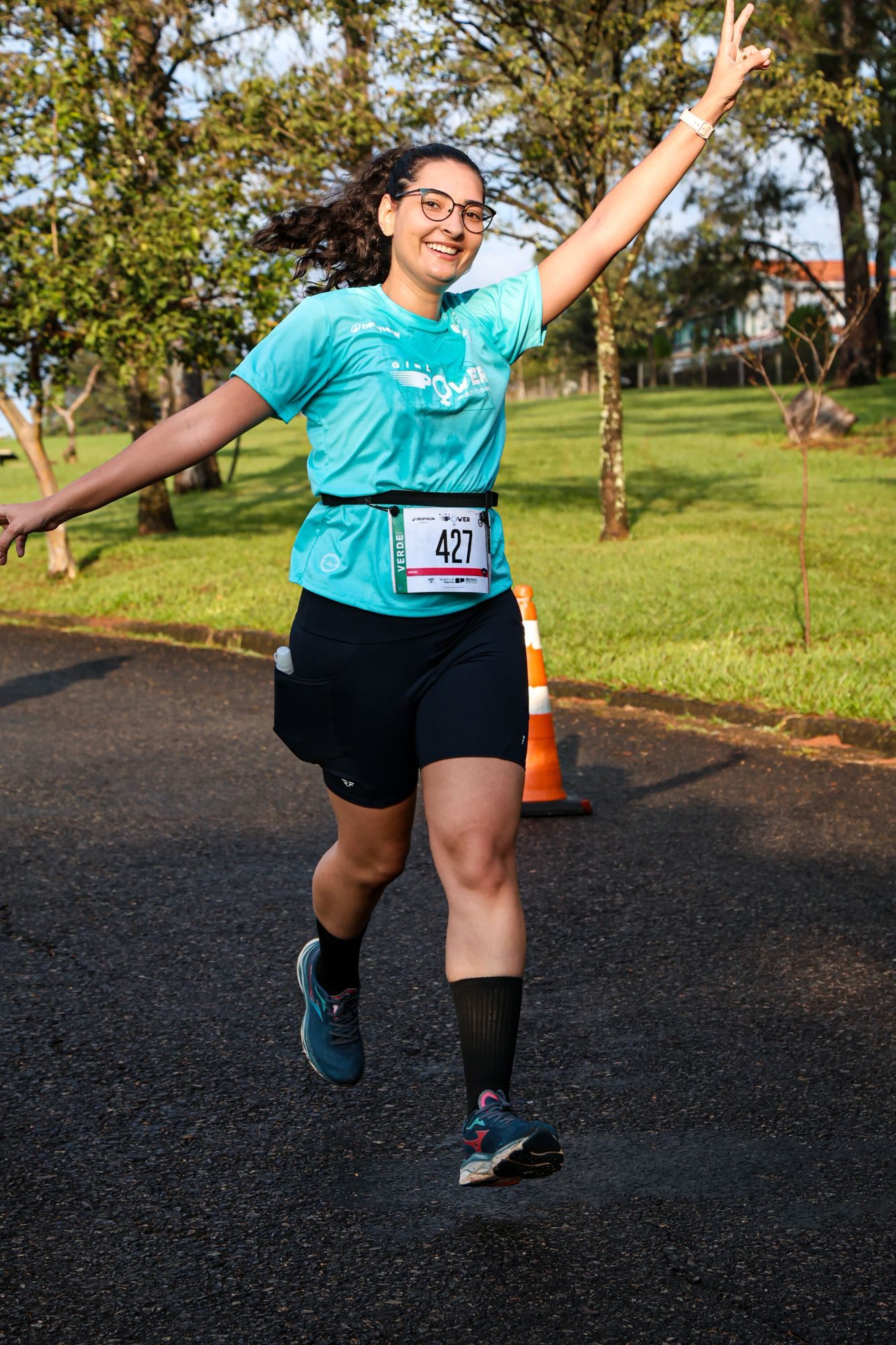 Gabriela correndo e sorrindo em uma corrida